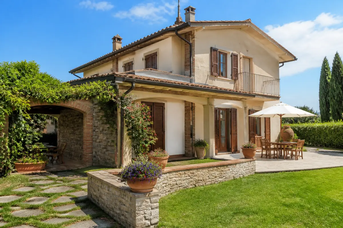 Elegante casa chiavi in mano con giardino, patio ombreggiato e facciata in pietra.